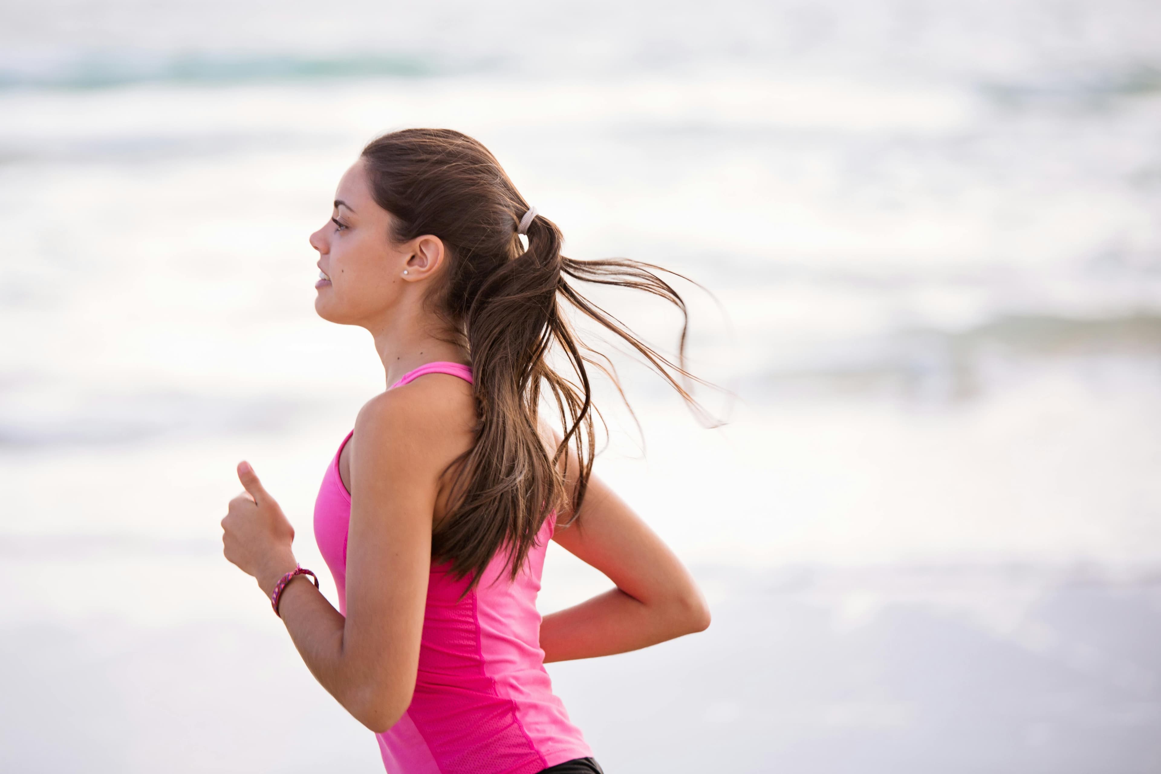 A woman running alongside a body of water